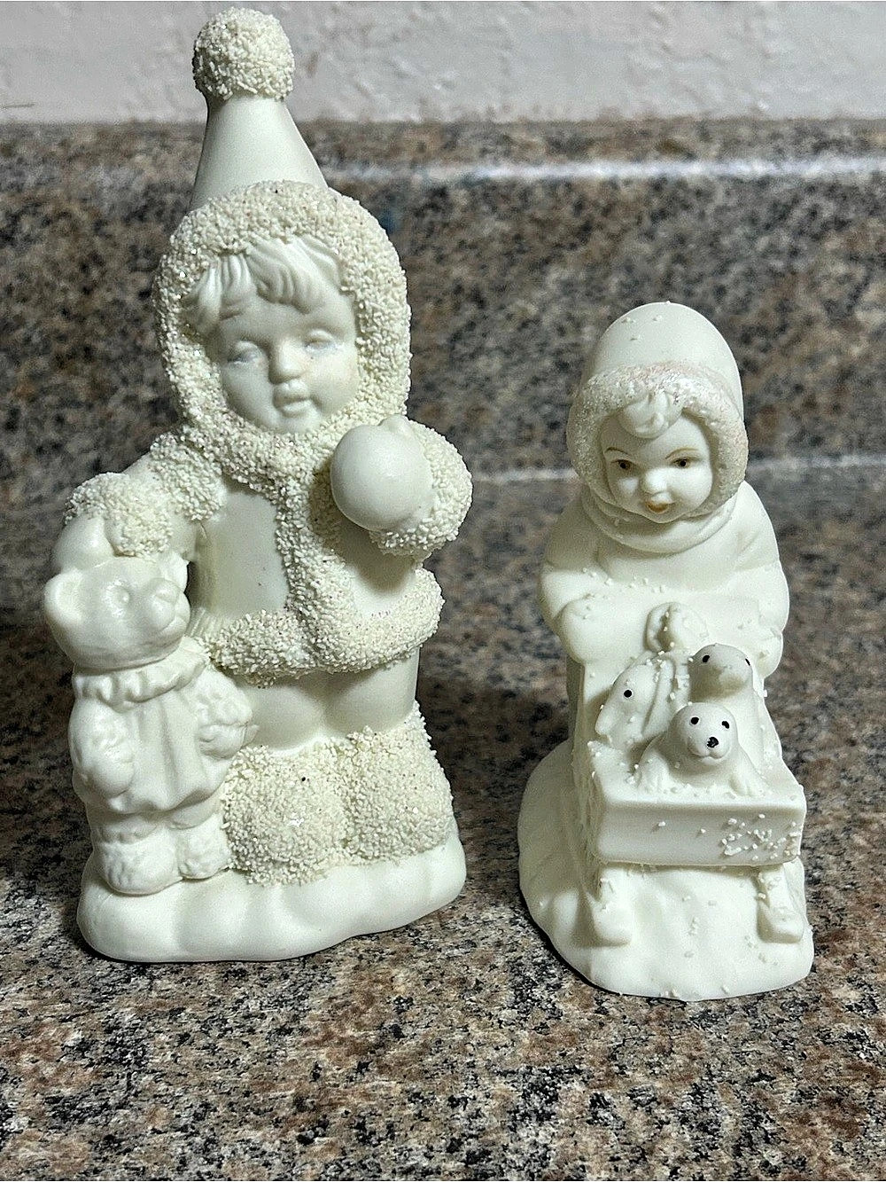 Vintage Porcelain Snowbabies Figurines. One pushing a sled and one with a Teddy